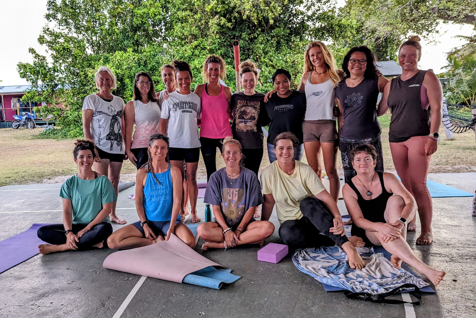 A large group posing together outdoors after a yoga session