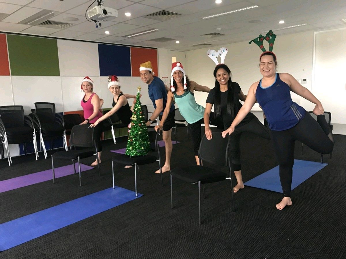 A team celebrating with a festive corporate yoga session