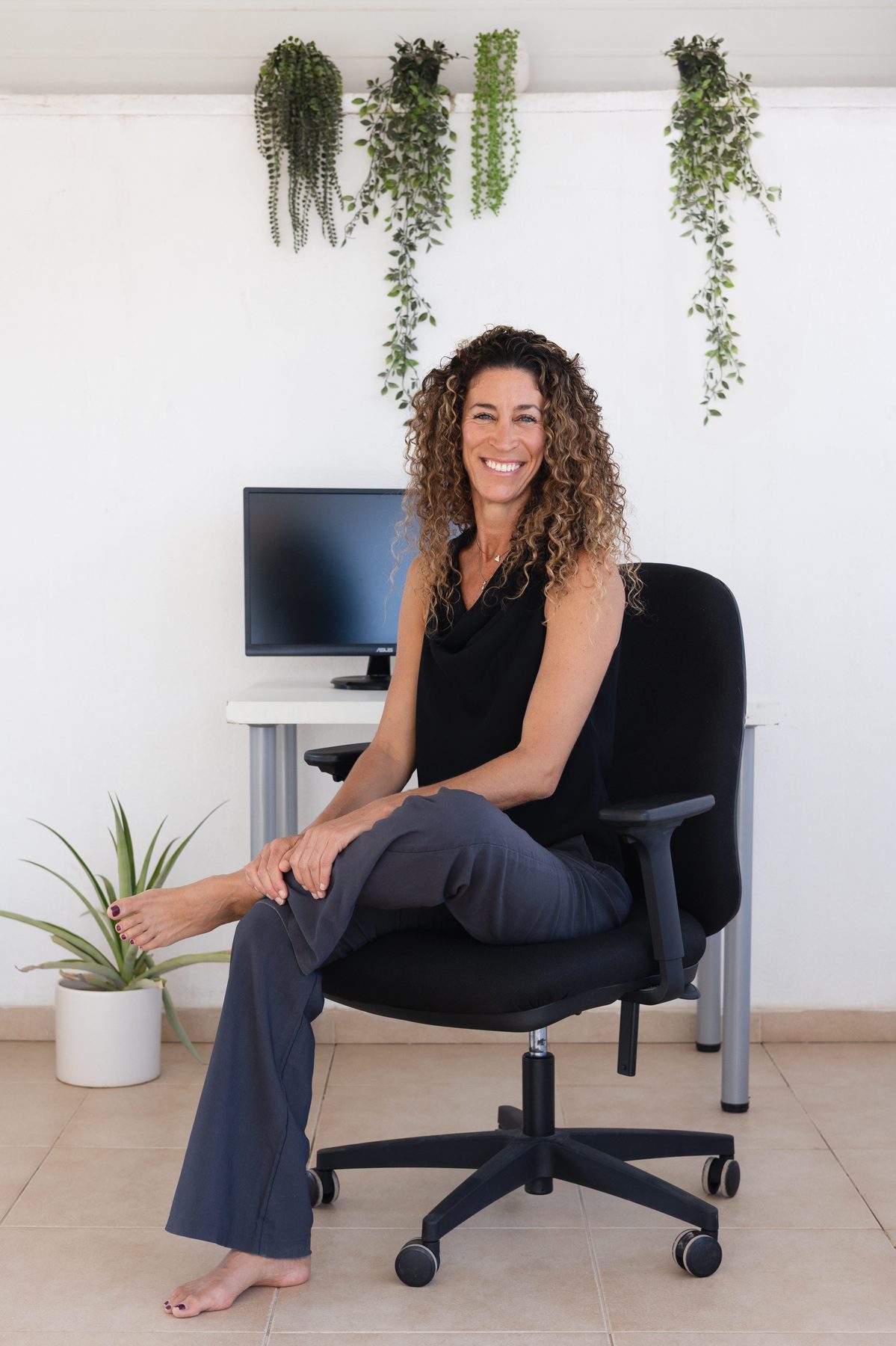 Shani Abergil, yoga therapist, smiling in her studio