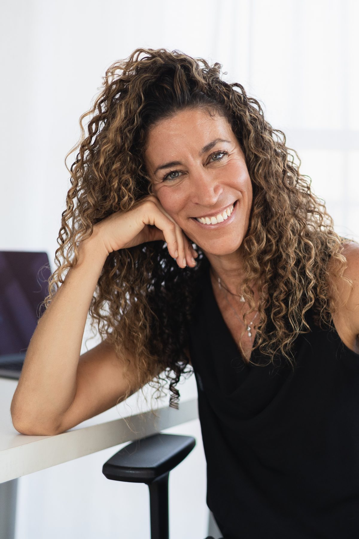 Shani smiling, seated, in her studio
